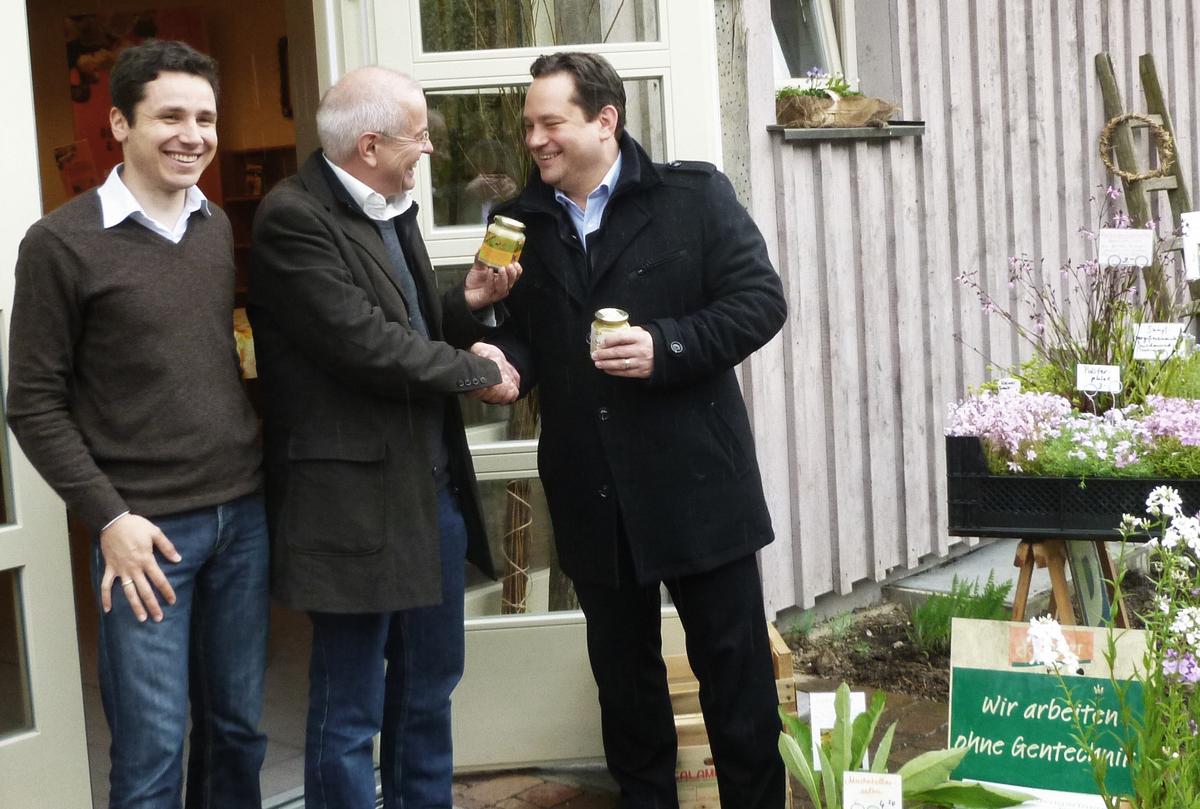 Ein Glas Honig zum Abschied f&uuml;r den Landwirtschaftsminister. Das Foto zeigt (v. l. n. r.) Holger Loritz, Thomas Radetzki und Minister Bonde vor dem Imkereigeb&auml;ude. 